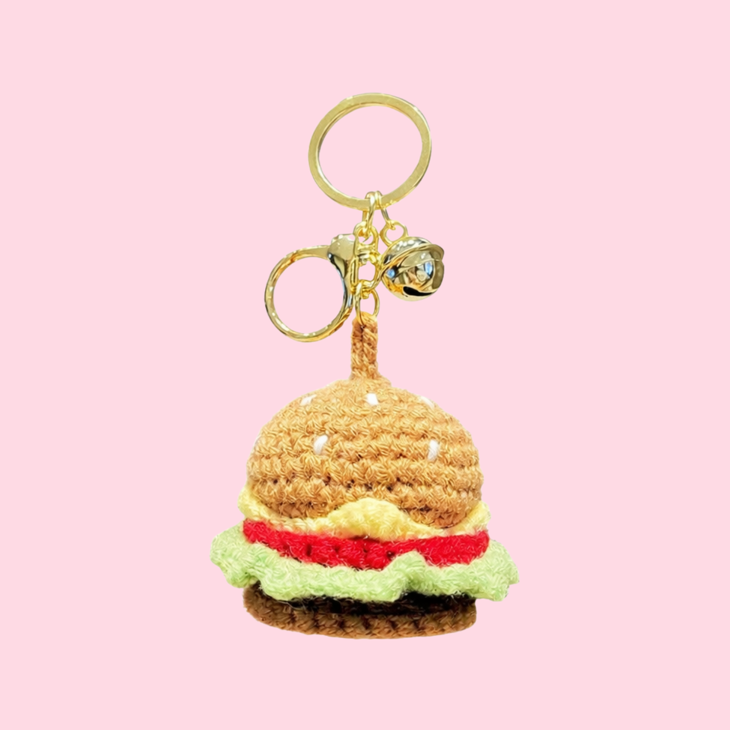 Crocheted hamburger keychain on a pink background