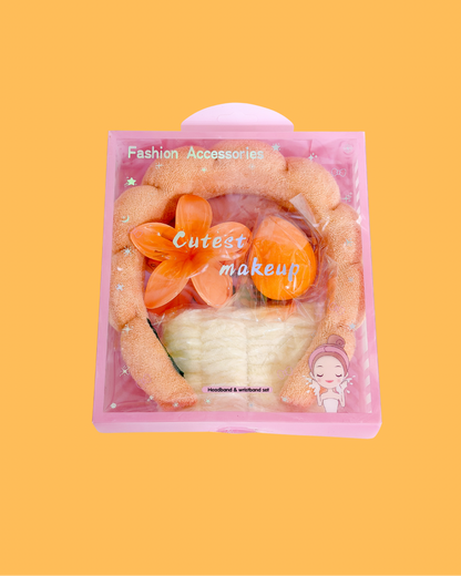 Sweetheart Spa Set packaged in a clear pink box, containing an orange fluffy headband, white wristbands, and orange makeup sponges.