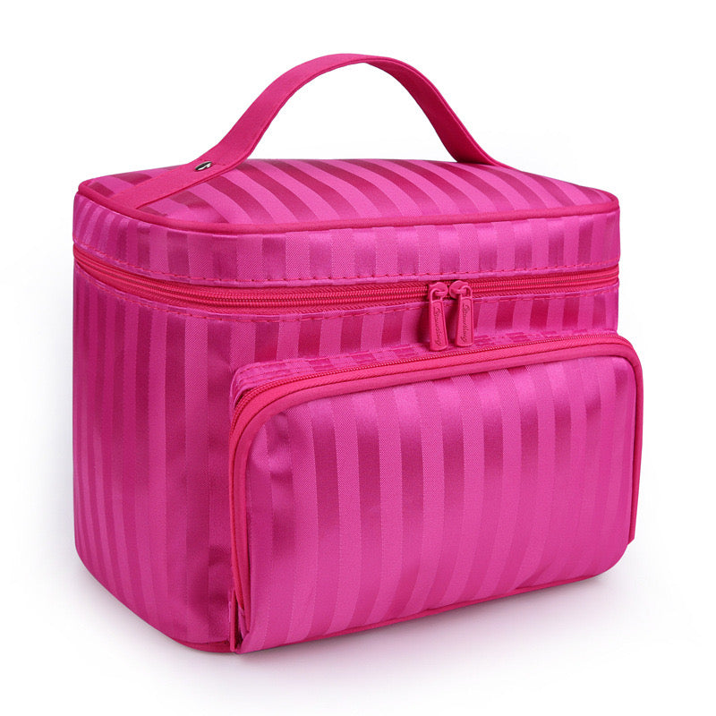 Hot pink striped Bella makeup bag with a top handle and zippered front pocket, side view.