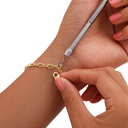 Silver Bracelet Clasp Helper Tool securing a gold chain bracelet on a person's wrist.