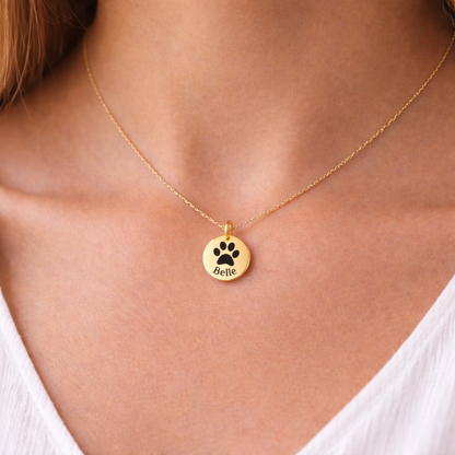 Gold pendant necklace with pet paw print and the name "Belle" engraved.